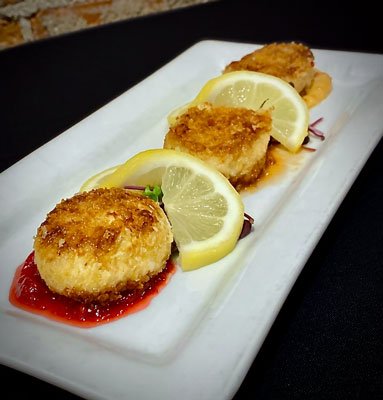 Crab cakes appetizer with raspberry jam and sweet chili aioli